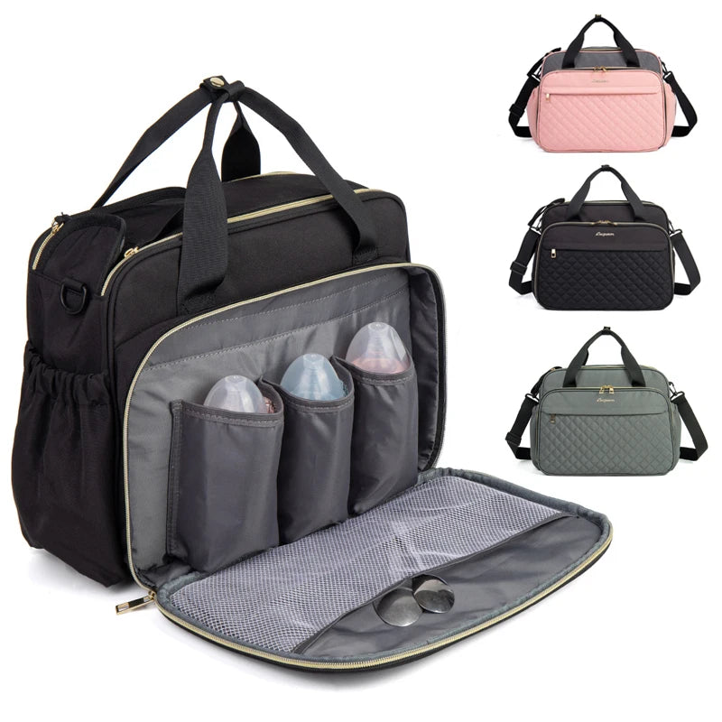 Black diaper bag with organizer pockets and additional bags in pink, gray, and black in the background.