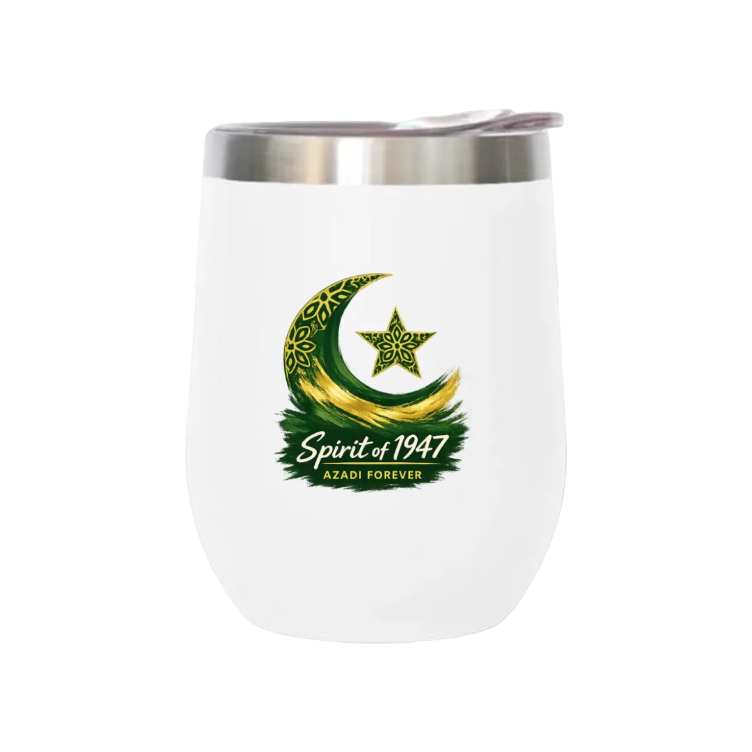 A white stemless wine tumbler with a stainless steel lid, featuring a green and gold crescent moon and star graphic with the text 'Spirit of 1947' and 'AZADI FOREVER' on the front, set against a solid light green background.
