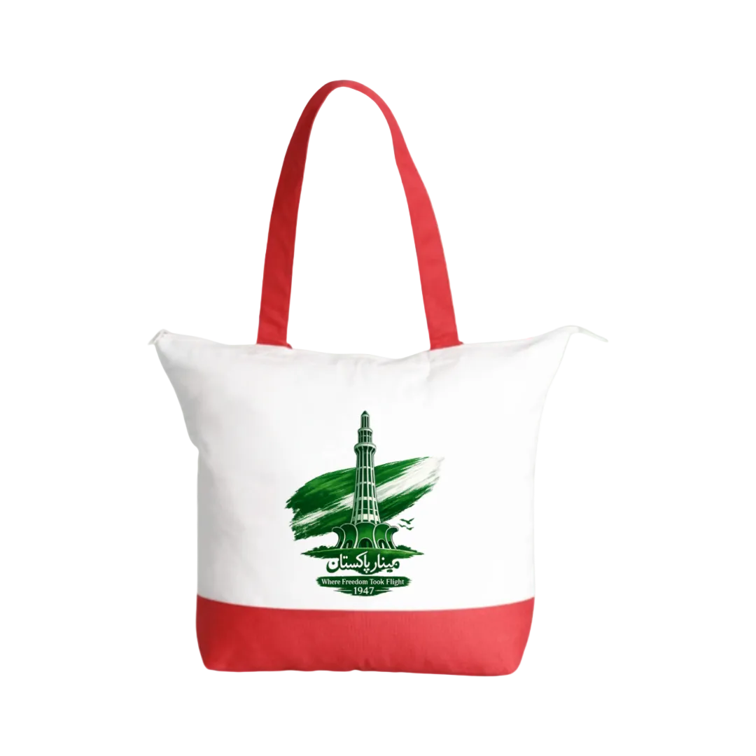 A white canvas tote bag with red handles and a red bottom band, featuring a green graphic of the Qutb Minar monument with Arabic calligraphy and the text 'MADINAH 600 FT' on the front, set against a solid light green background.