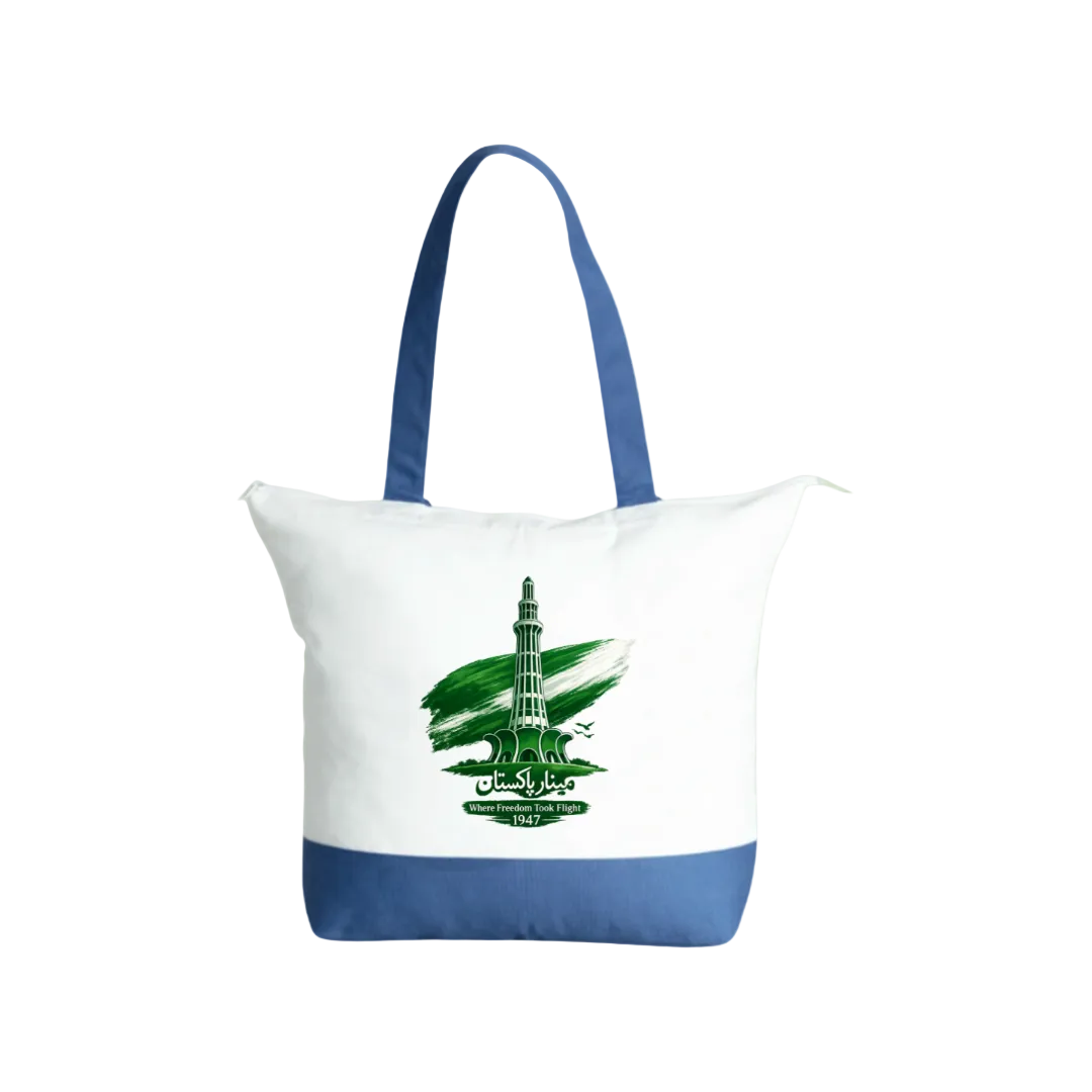 A white canvas tote bag with blue handles and a blue bottom band, featuring a green graphic of a minaret and the text 'MADINAH 625 FT' on the front, set against a solid light green background.
