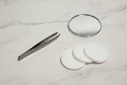 Orial tweezer flat-lay on marble surface with beauty accessories
