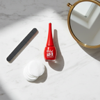 Orial Gel red nail polish flat-lay on marble with beauty accessories