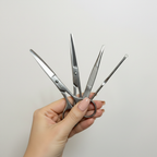 Hand holding Orial beauty grooming set - scissors, tweezers and blackhead tool